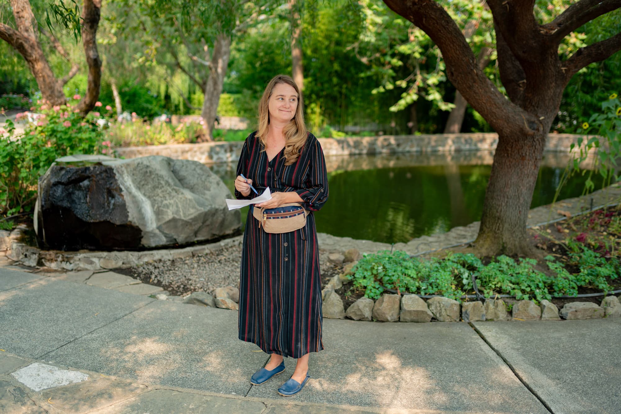 Day-of coordinator pouring champagne at a garden reception