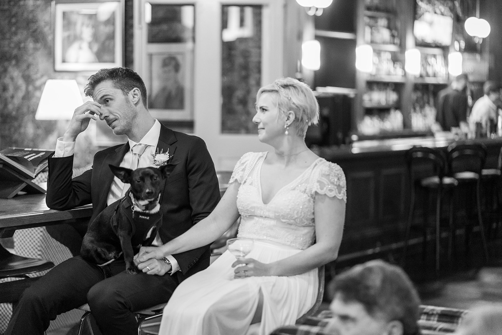 Couple with their dog at wedding — candid bar moment