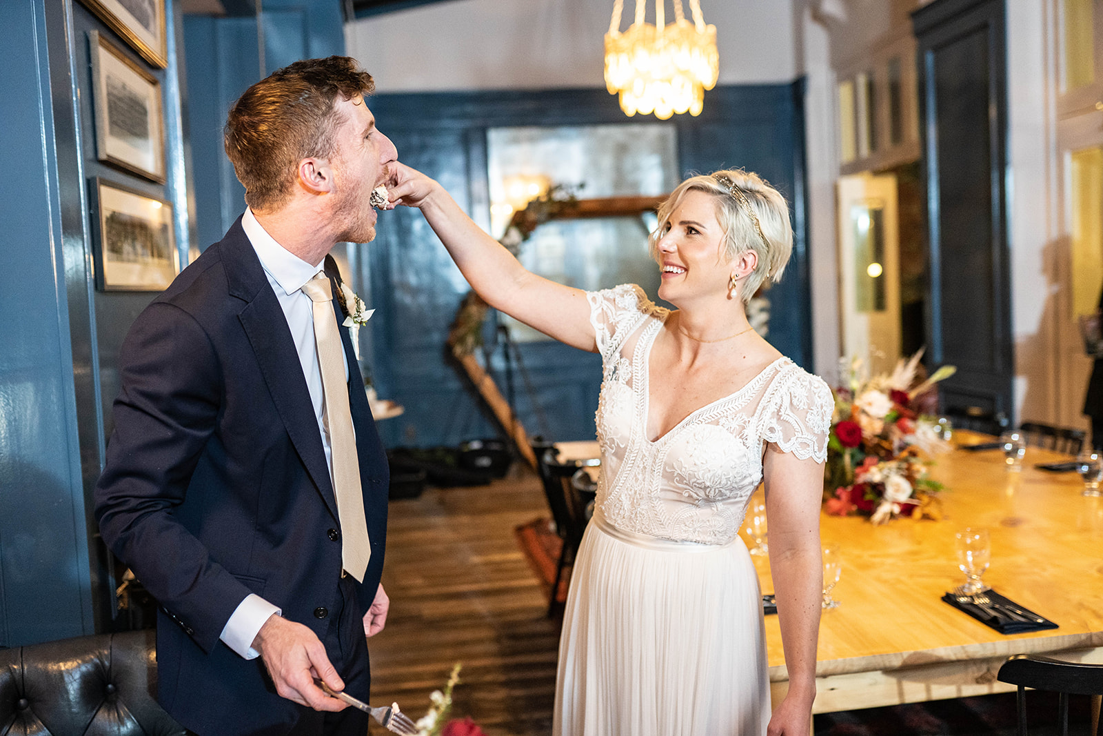 Couple laughing during cake at their reception
